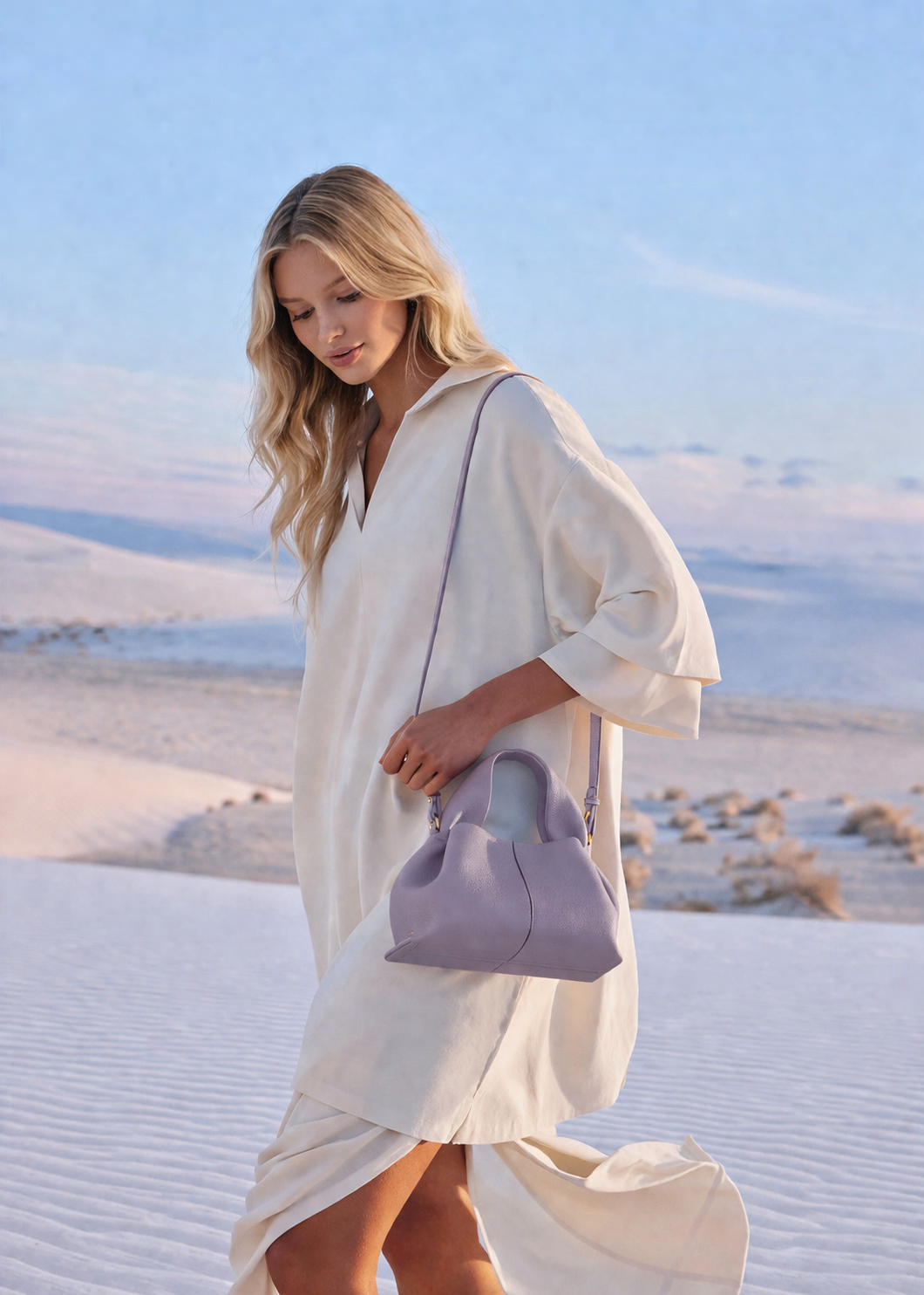 Elegant Minimalist Resort Look Featuring Flowing Ivory Tunic Dress and Draped Neutral Layers with Structured Soft Lilac Leather Top Handle Handbag – Modern Quiet Luxury Womenswear Editorial Style