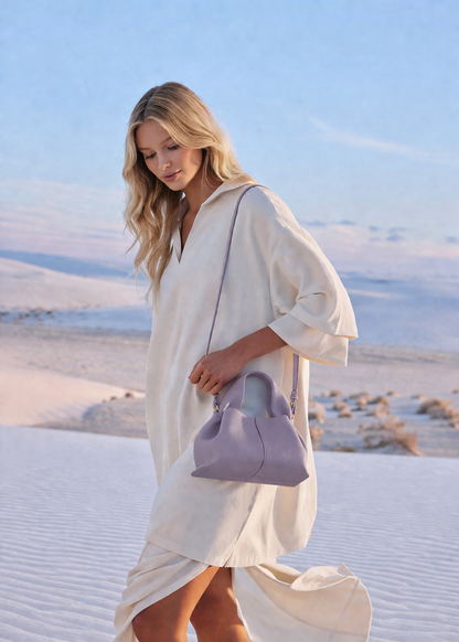 Elegant Minimalist Resort Look Featuring Flowing Ivory Tunic Dress and Draped Neutral Layers with Structured Soft Lilac Leather Top Handle Handbag – Modern Quiet Luxury Womenswear Editorial Style