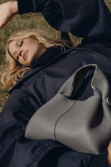 Elegant Minimalist Slate Grey Pebbled Leather Top Handle Handbag with Soft Sculptural Silhouette and Gold Hardware – Modern Quiet Luxury Designer Accessory Product Shot