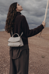 Elegant Ivory Pebbled Leather Top-Handle Shoulder Bag with Fold-Over Flap and Adjustable Strap Styled in Cozy Knitwear Portrait