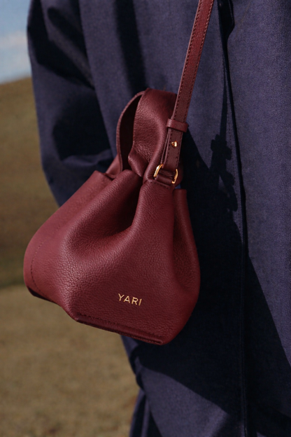 Refined Minimalist Winter Outfit Featuring Soft Ivory Textured Coat and Cream Tailored Trousers with Deep Burgundy Leather Crossbody Top Handle Handbag – Elegant Quiet Luxury Womenswear Editorial Style