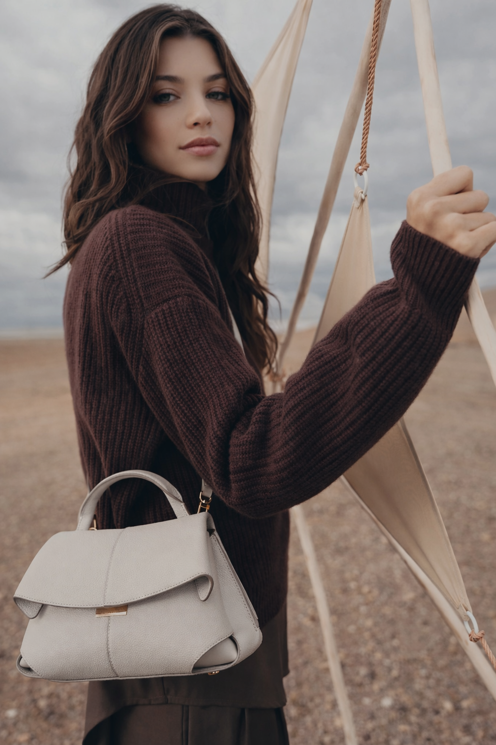 Elegant Ivory Pebbled Leather Top-Handle Shoulder Bag with Fold-Over Flap and Adjustable Strap Styled in Cozy Knitwear Portrait
