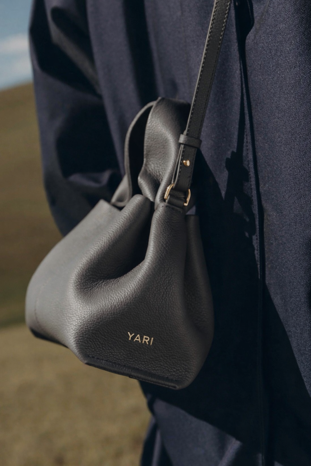 Elegant Minimalist Slate Grey Pebbled Leather Top Handle Handbag with Soft Sculptural Silhouette and Gold Hardware – Modern Quiet Luxury Designer Accessory Product Shot