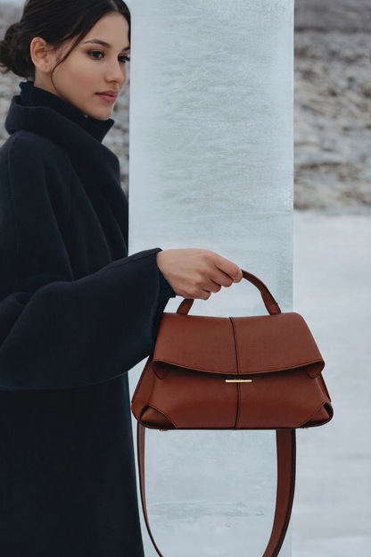 Elegant Cognac Pebbled Leather Top-Handle Shoulder Bag with Fold-Over Flap, Adjustable Strap, and Gold-Tone Hardware Styled in Modern Winter Look