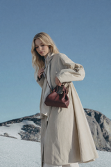 Refined Minimalist Winter Outfit Featuring Soft Ivory Textured Coat and Cream Tailored Trousers with Deep Burgundy Leather Crossbody Top Handle Handbag – Elegant Quiet Luxury Womenswear Editorial Style