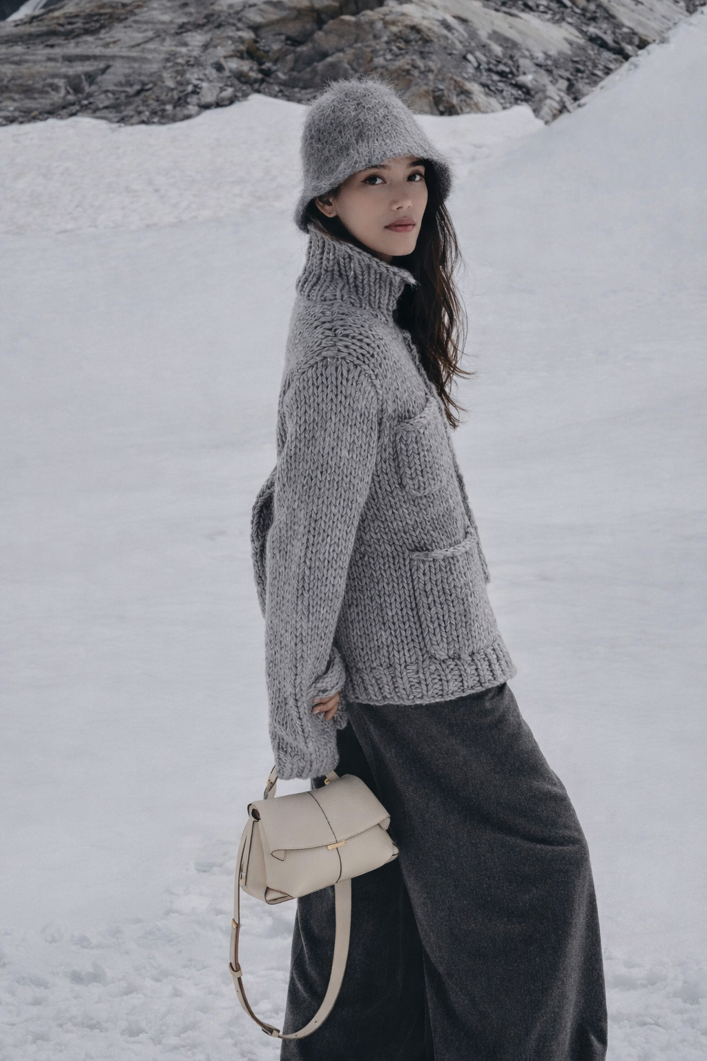 Elegant Taupe Pebbled Leather Top-Handle Crossbody Bag with Fold-Over Flap and Adjustable Strap Styled with Oversized Chunky Knit Sweater