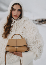 Elegant Camel Pebbled Leather Top-Handle Handbag with Fold-Over Flap, Adjustable Strap, and Gold-Tone Hardware Styled in Luxe Winter Look