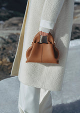 Elegant Winter Minimalist Look Featuring Ivory Textured Wool Coat and Cream Tailored Trousers with Structured Cognac Leather Top Handle Handbag – Timeless Quiet Luxury Womenswear Editorial Style