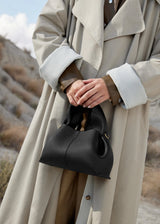 Sophisticated Minimalist Trench Coat Ensemble Featuring Oversized Stone Beige Outerwear and Layered Neutral Tailoring with Structured Black Leather Top Handle Handbag – Modern Quiet Luxury Womenswear Editorial Look