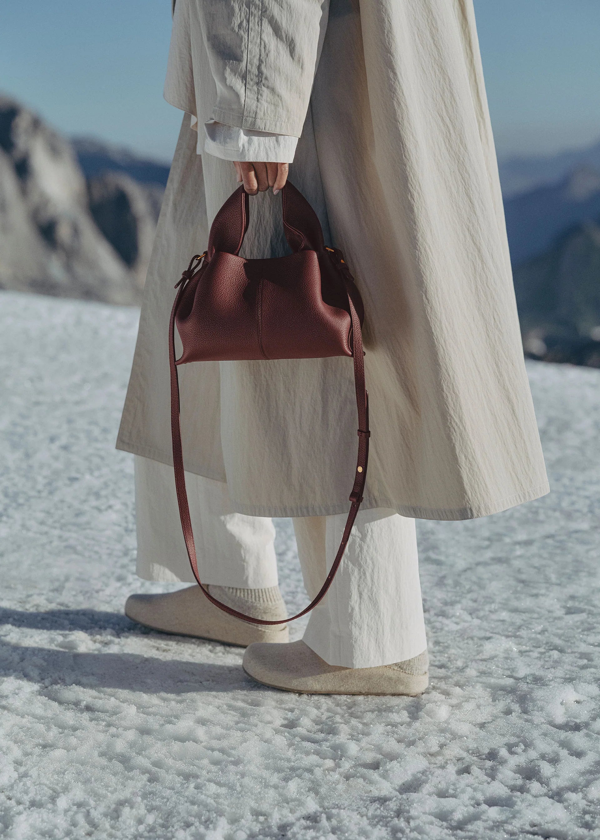 Refined Minimalist Winter Outfit Featuring Soft Ivory Textured Coat and Cream Tailored Trousers with Deep Burgundy Leather Crossbody Top Handle Handbag – Elegant Quiet Luxury Womenswear Editorial Style