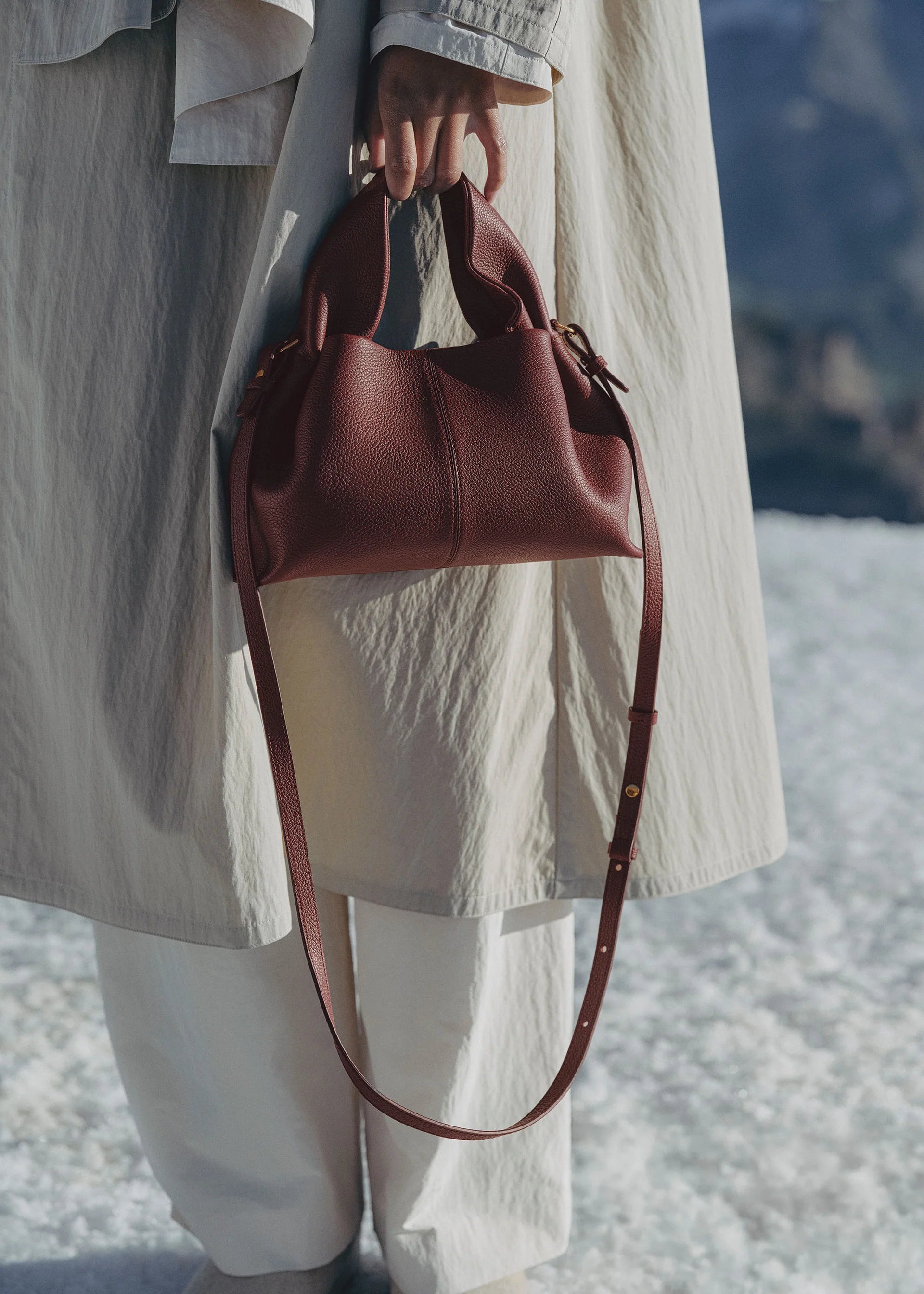 Refined Minimalist Winter Outfit Featuring Soft Ivory Textured Coat and Cream Tailored Trousers with Deep Burgundy Leather Crossbody Top Handle Handbag – Elegant Quiet Luxury Womenswear Editorial Style