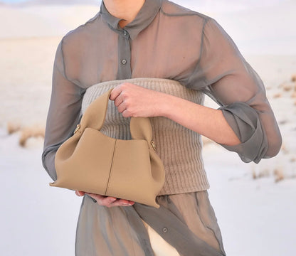 Modern Minimalist Neutral Outfit Featuring Sheer Taupe Button-Up Shirt Layered Over Ribbed Knit Bustier with Flowing Trousers and Structured Sand Beige Leather Top Handle Handbag – Elegant Contemporary Womenswear Editorial Look