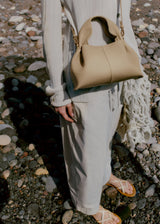 Relaxed Minimalist Coastal Look Featuring Ribbed Oatmeal Knit Cardigan and Soft Neutral Wide-Leg Trousers with Structured Sand Beige Leather Crossbody Handbag – Effortless Quiet Luxury Womenswear Editorial Style