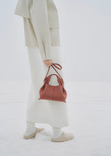 Elegant Minimalist Winter Look Featuring Soft Ivory Textured Coat with Structured Deep Burgundy Leather Crossbody Top Handle Handbag – Timeless Quiet Luxury Womenswear Editorial Style