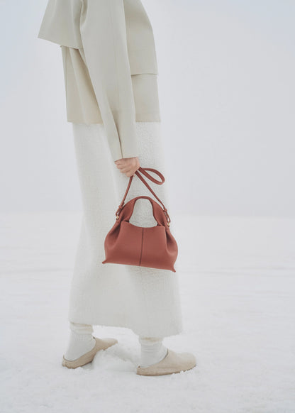 Elegant Minimalist Winter Look Featuring Soft Ivory Textured Coat with Structured Deep Burgundy Leather Crossbody Top Handle Handbag – Timeless Quiet Luxury Womenswear Editorial Style