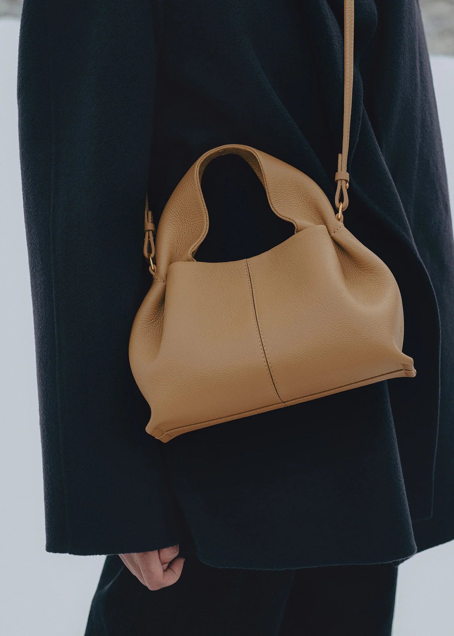 Sophisticated Minimalist Winter Look Featuring Oversized Black Wool Coat with Structured Camel Leather Crossbody Top Handle Handbag – Modern Quiet Luxury Womenswear Editorial Style