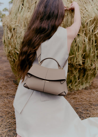 Taupe Leather Top-Handle Shoulder Bag Styled on Model in Neutral Sleeveless Dress