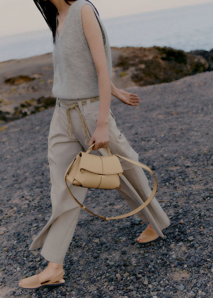 Elegant Beige Pebbled Leather Top-Handle Handbag with Fold-Over Flap and Minimalist Structured Silhouette Styled in Soft Neutral Look