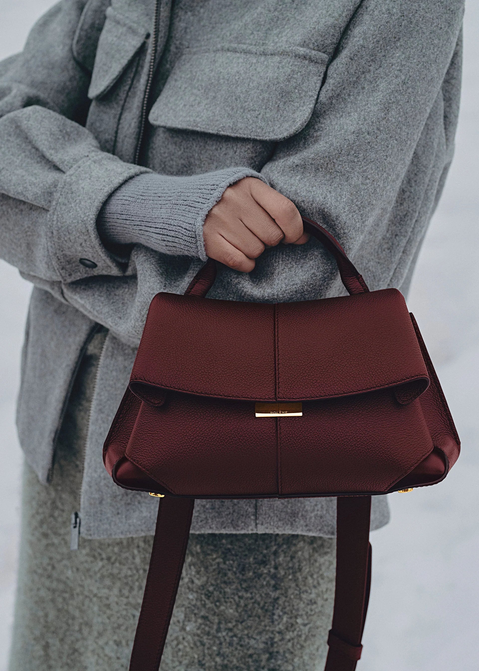 Elegant Burgundy Pebbled Leather Top-Handle Shoulder Bag with Fold-Over Flap and Gold-Tone Hardware Styled with Cozy Grey Outerwear