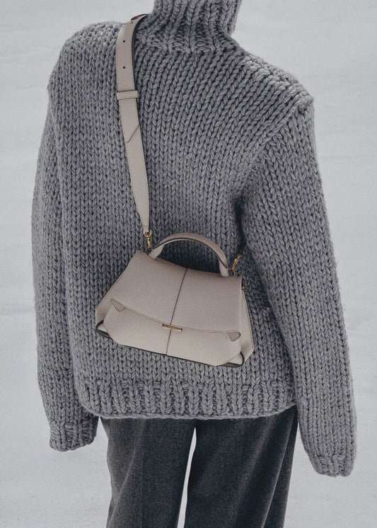 Elegant Taupe Pebbled Leather Top-Handle Crossbody Bag with Fold-Over Flap and Adjustable Strap Styled with Oversized Chunky Knit Sweater