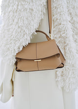 Elegant Camel Pebbled Leather Top-Handle Handbag with Fold-Over Flap, Adjustable Strap, and Gold-Tone Hardware Styled in Luxe Winter Look