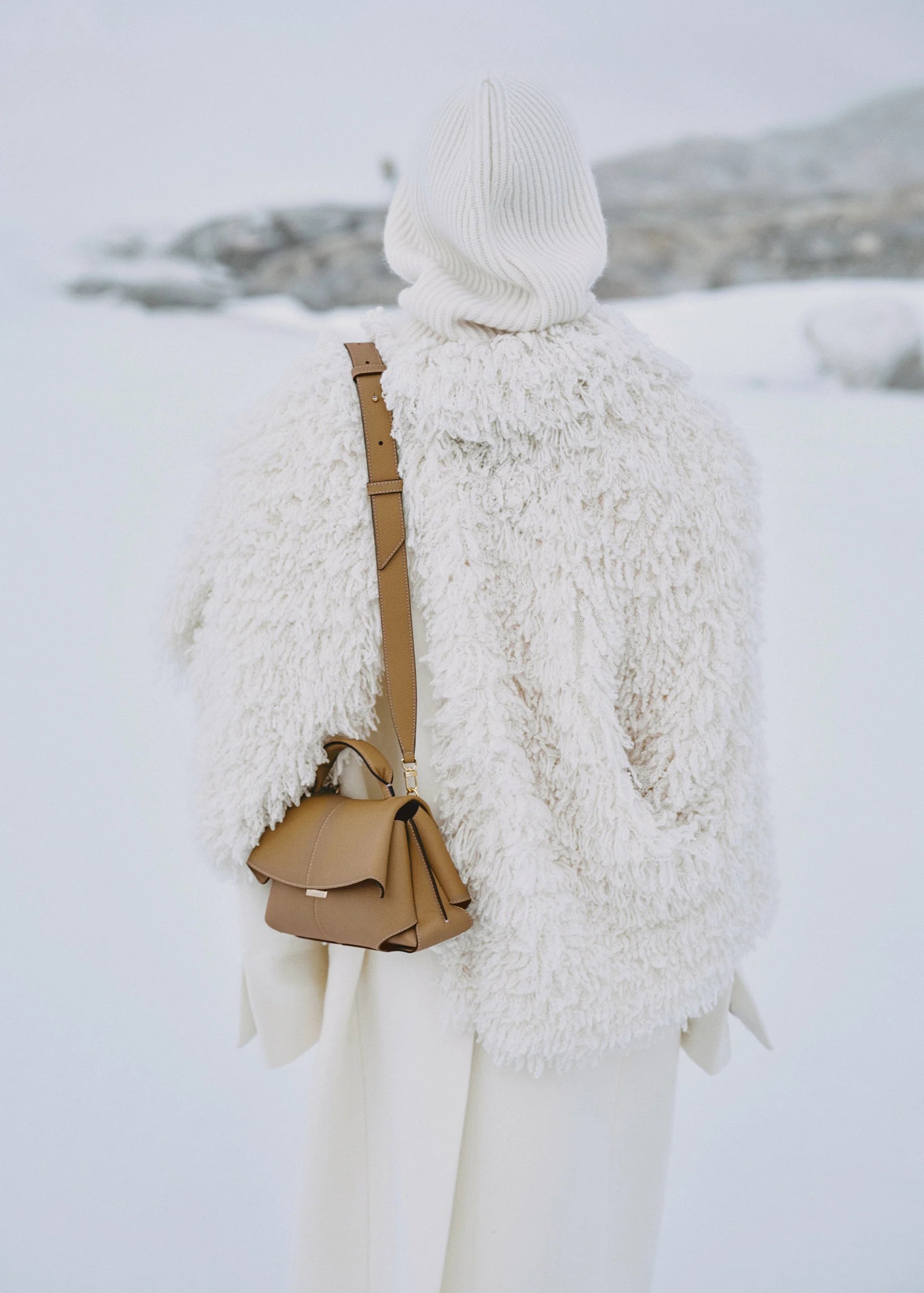 Elegant Camel Pebbled Leather Top-Handle Handbag with Fold-Over Flap, Adjustable Strap, and Gold-Tone Hardware Styled in Luxe Winter Look