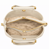 Smooth minimalist front panel enhanced with a structured flap detail and a detachable gold charm chain featuring pearl and mini handbag accents for a refined luxury-inspired finish.